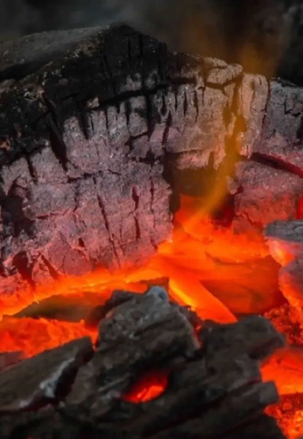 Un primer plano de brasas en una cocina de leña.