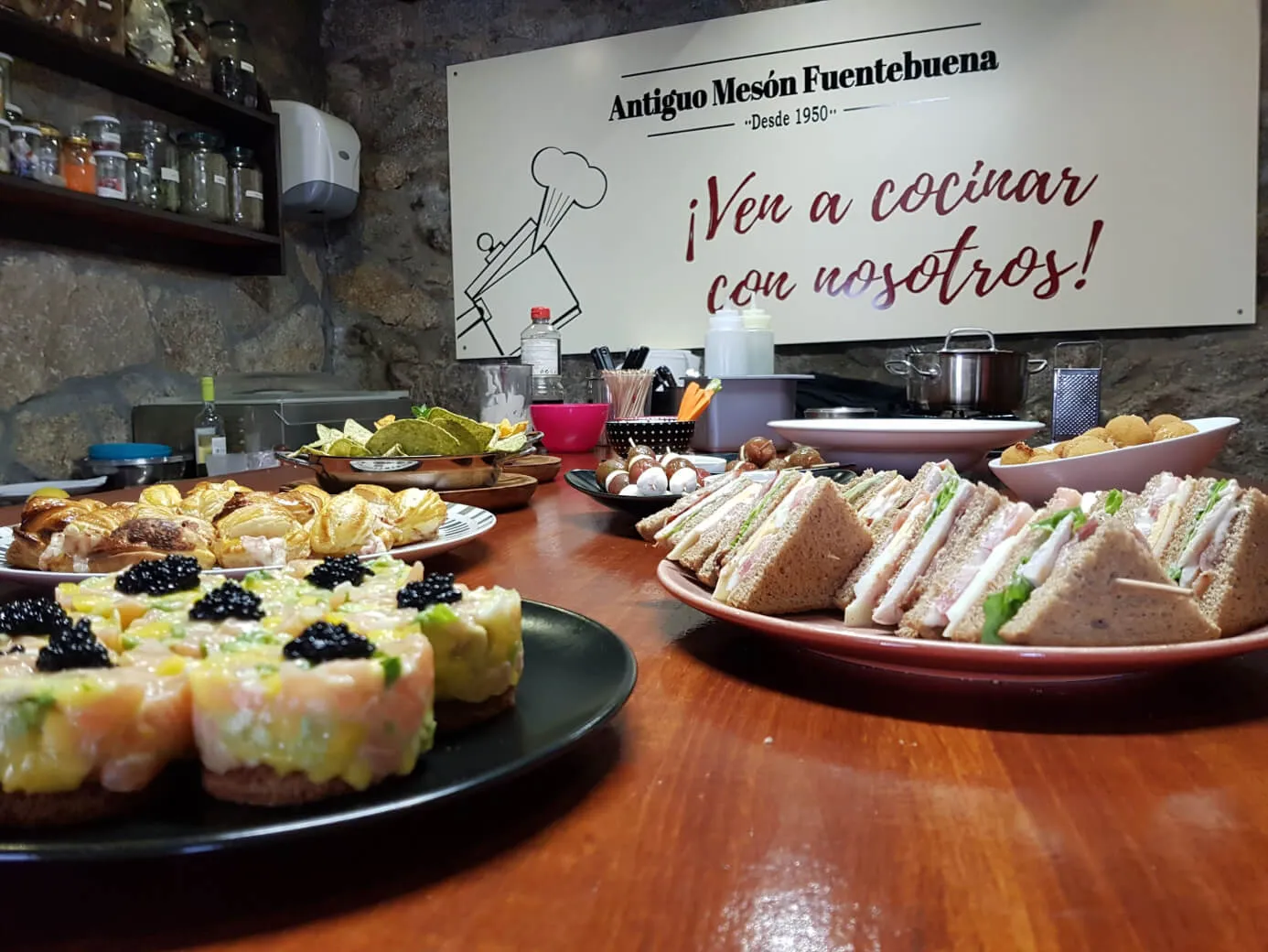 Una mesa de madera cubierta con platos de comida cocinados en una clase de cocina.