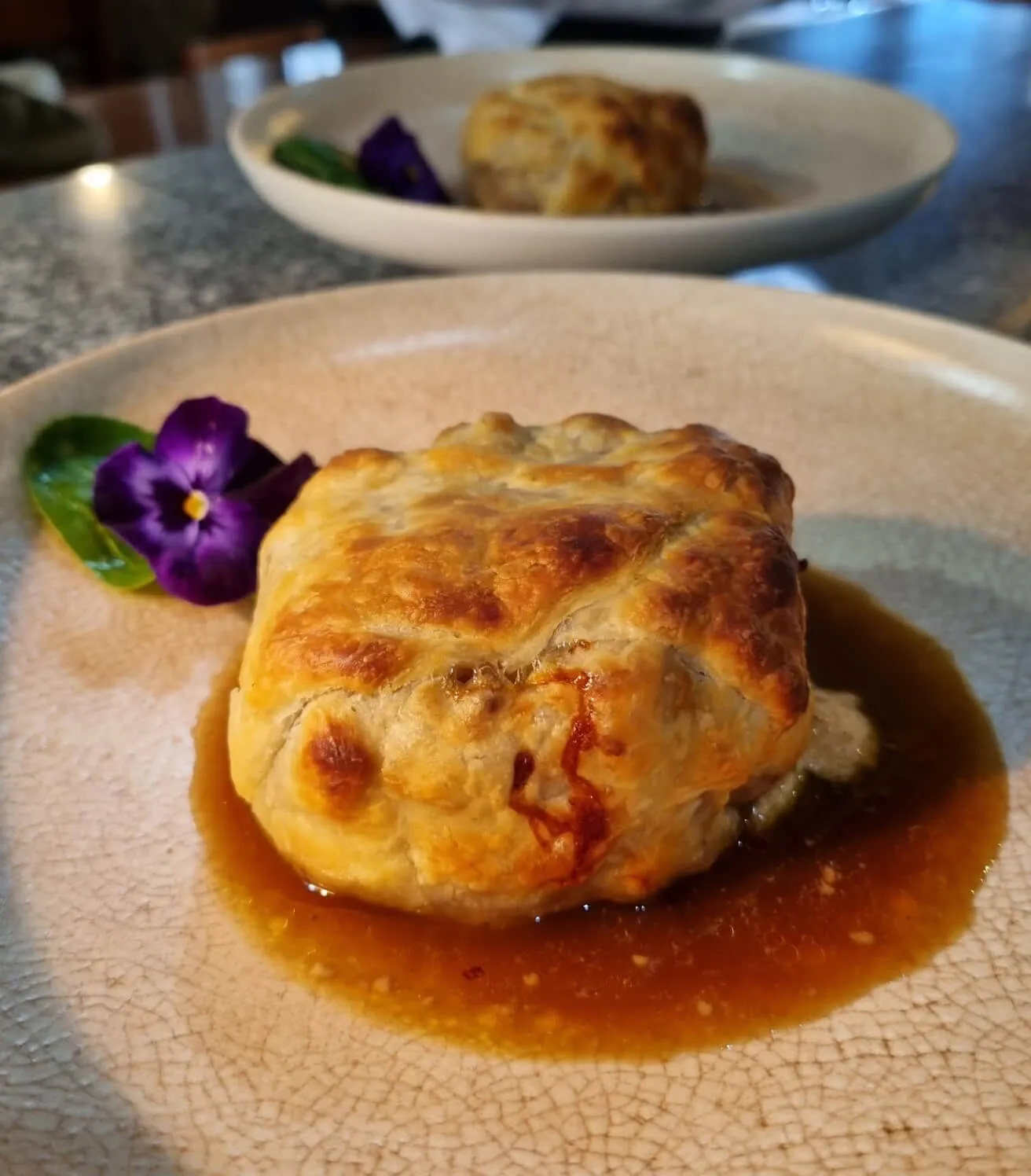 Hojaldre relleno de manitas de cerdo en un plato.