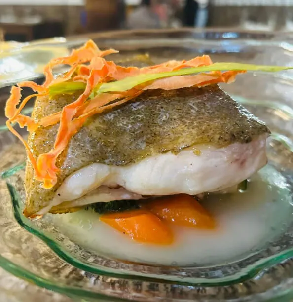 Un trozo de lomo de rodaballo a la brasa en un plato de cristal.