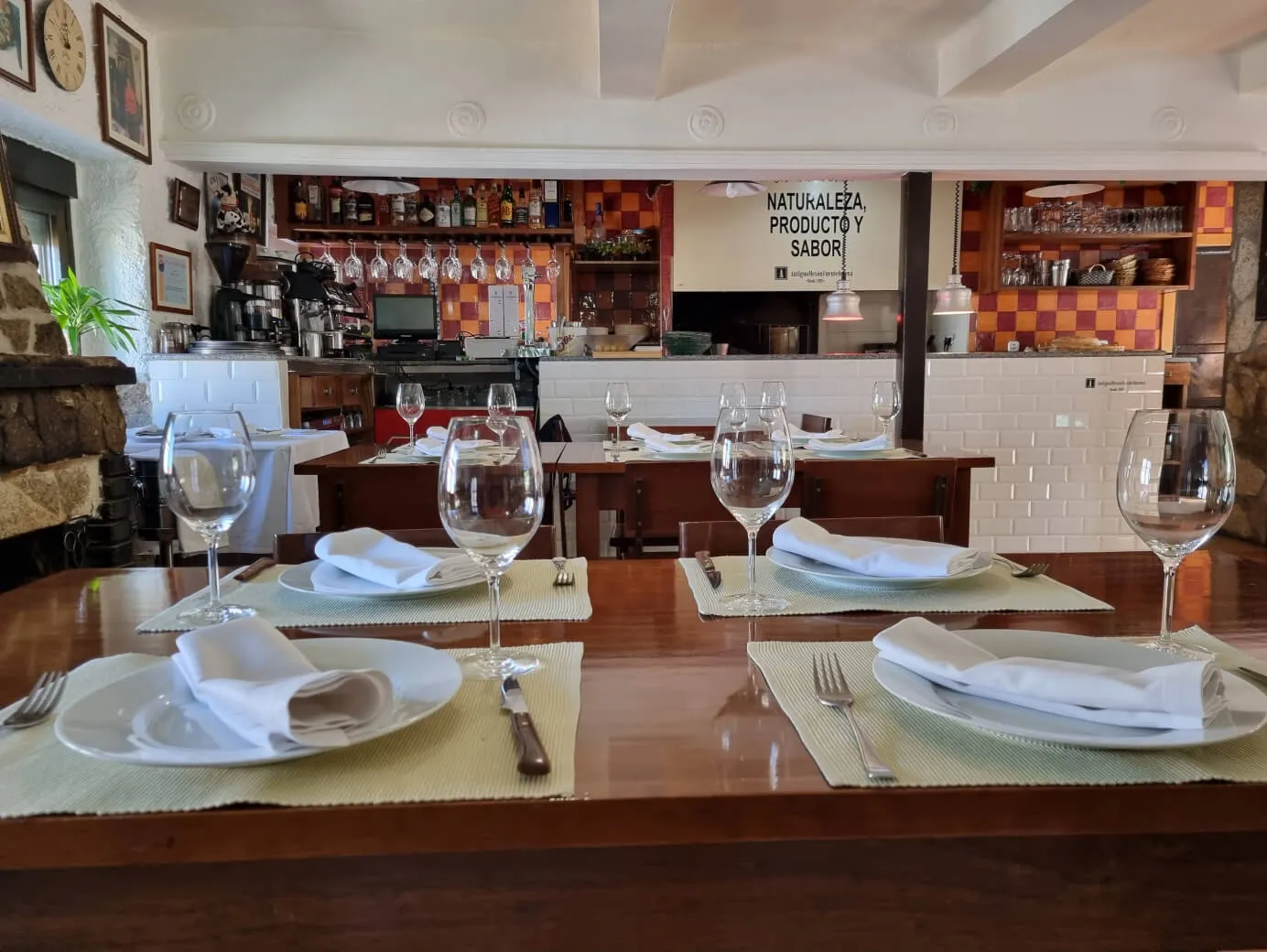 Comedor principal de Antiguo Mesón Fuentebuena con la cocina al fondo.